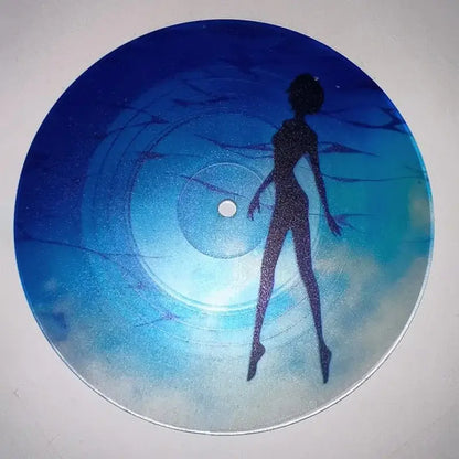 A circular blue vinyl evangelion ayanami rei acrylic coaster with a glittery woman silhouette on a gradient ocean background