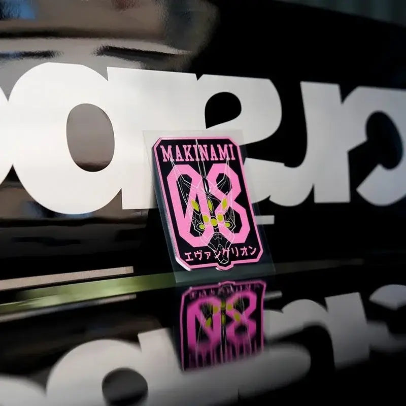 Pink and black reflective car sticker with makina logo, stylized 08, yellow accents, and japanese text for windshield use