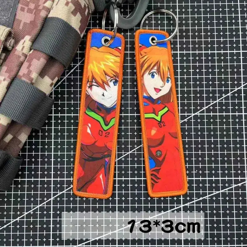 Orange embroidered evangelion key tag featuring a smiling anime character in red and green armor keychain accessory