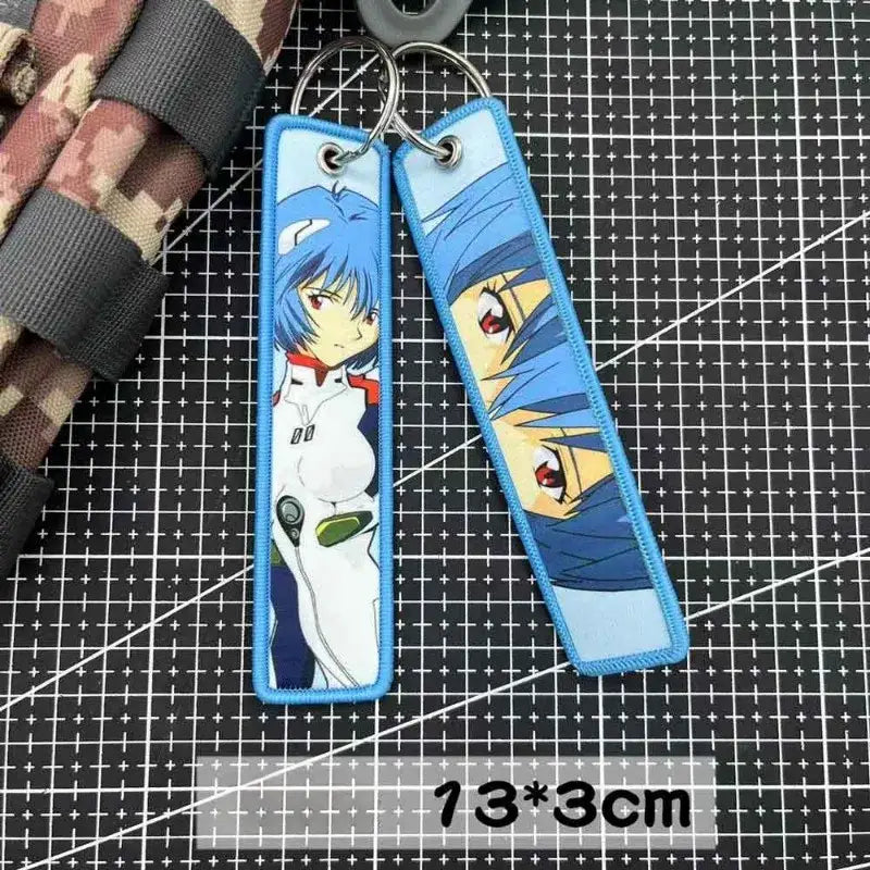 Blue embroidered key tag featuring evangelion anime designs with stitched edges and metal ring backpack charm
