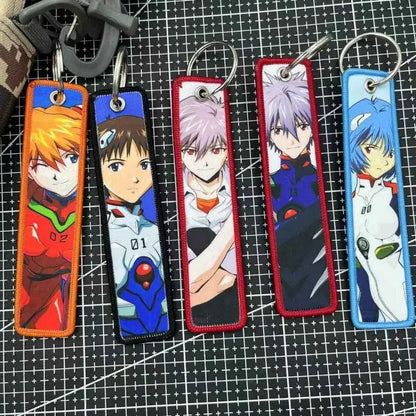 Five rectangular embroidered Evangelion key tags with colorful borders designed as backpack charms