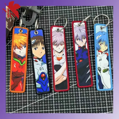 Five rectangular evangelion embroidered key tags with colorful borders used as backpack charms