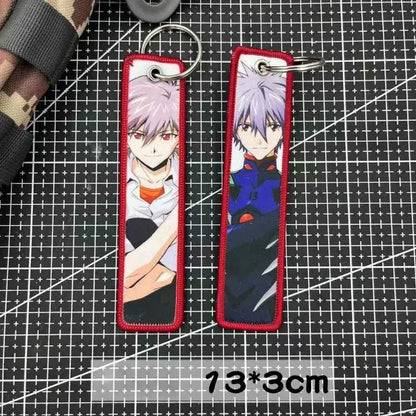Two embroidered evangelion key tags with silver hair and red eyes in red borders used as backpack charms