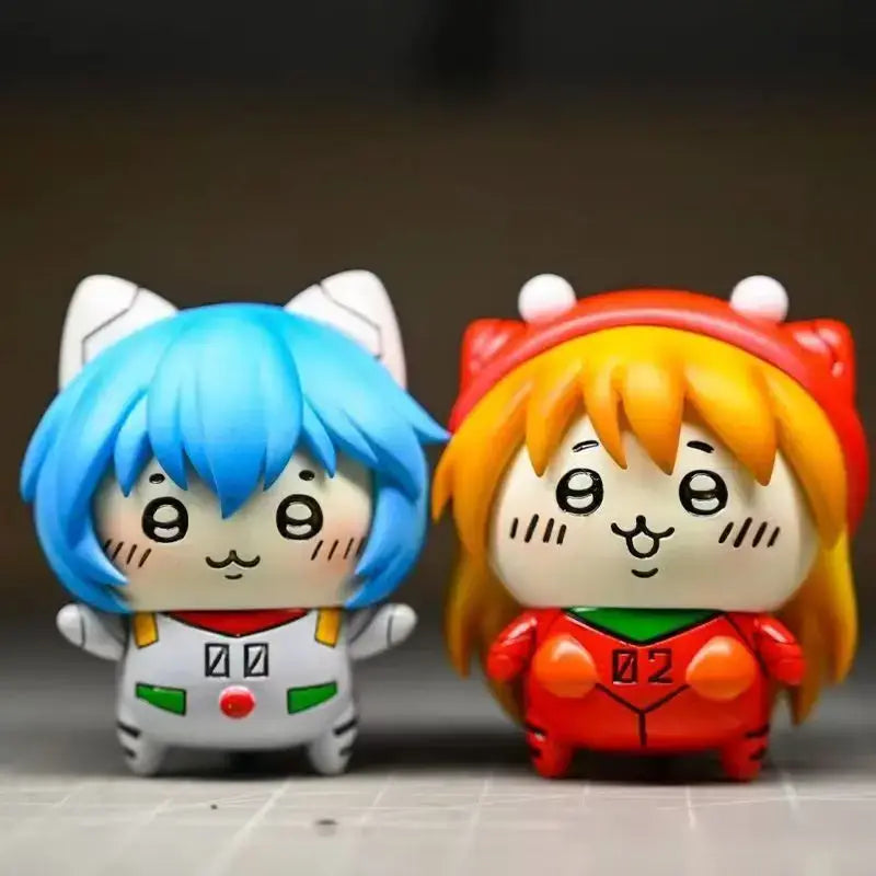 Two chibi-style evangelion rei asuka pvc figures with oversized ears, colorful outfits, and cartoonish faces for desktop display