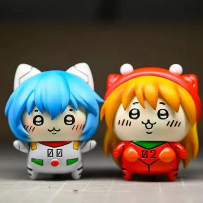 Two chibi-style evangelion rei asuka pvc figures with oversized ears, colorful outfits, and cartoonish faces for desktop display