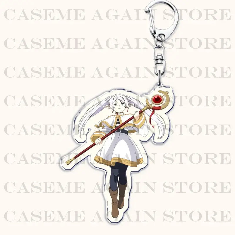 Clear acrylic keychain featuring frieren anime character in white and gold outfit holding red-tipped staff bag charm