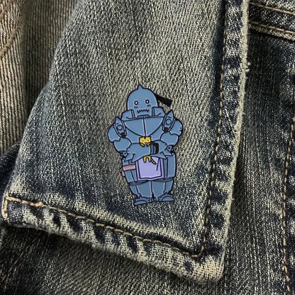A blue metallic enamel alphonse elric enamel pin featuring a cartoonish armored character with a yellow face