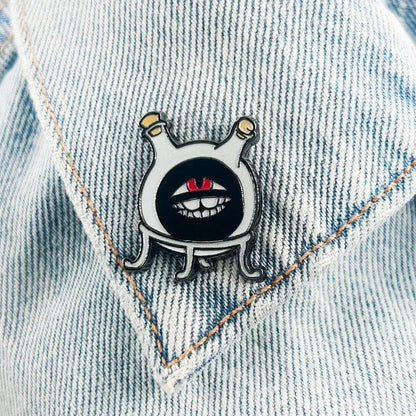 Fullmetal alchemist dwarf white enamel flask lapel pin featuring a cartoonish creature with black eyes and red pupils