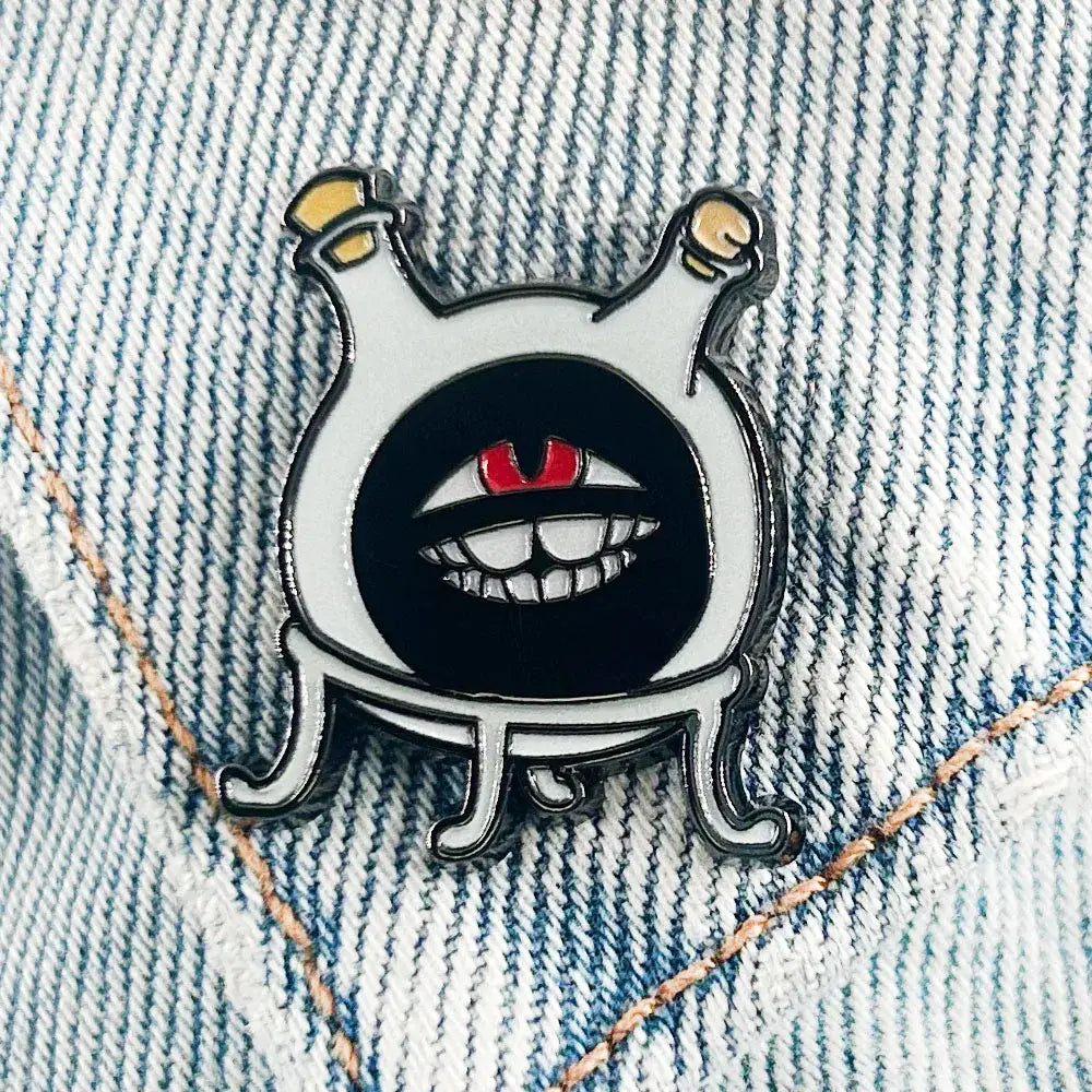 White enamel fullmetal alchemist dwarf flask lapel pin featuring a cartoon creature with red eyes and yellow antennae