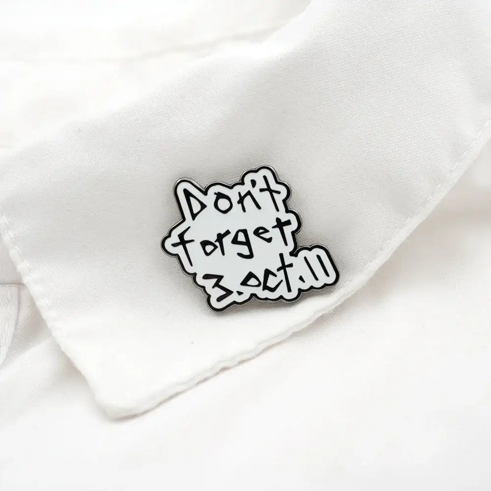Black and white enamel pin with playful fullmetal alchemist edward elric design pinned on white fabric fullmetal alchemist edward