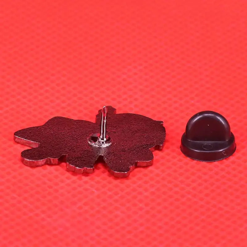 Dark red enamel pin shaped like a stylized flower with metallic edges and silver fastener fullmetal alchemist edward elric