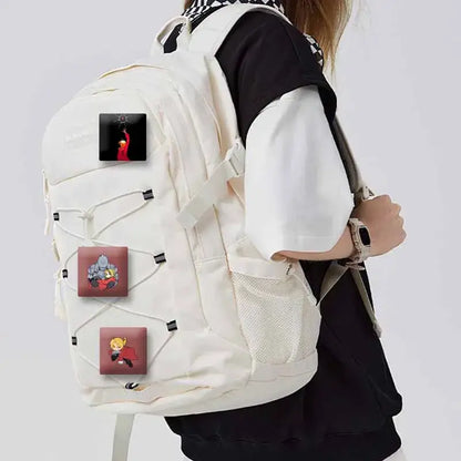 Cream-colored canvas backpack with three fullmetal alchemist edward elric anime patches and lapel brooch pins