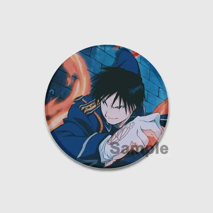 Circular fullmetal alchemist enamel brooch featuring anime character in dark blue uniform with gold trim on fiery background
