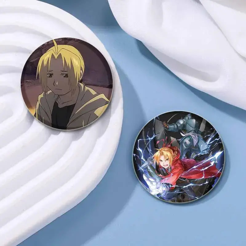Two fullmetal alchemist enamel brooches featuring a blonde character and a vibrant action scene with lightning effects