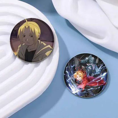 Two fullmetal alchemist enamel brooches featuring a blonde character and a vibrant action scene with lightning effects