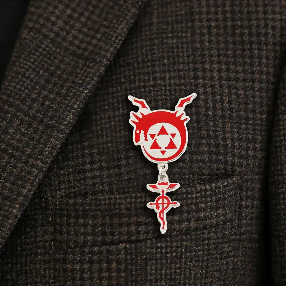 Red and white enamel pin featuring fullmetal alchemist flamel homunculus logo with flame horns and silver chain suspension