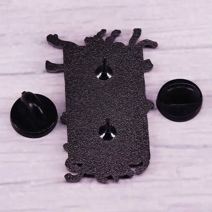 Black glittery monster-shaped fullmetal alchemist gate of truth enamel pin with silver fasteners and black backing