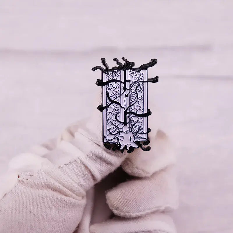 Black and silver fullmetal alchemist gate of truth enamel pin with detailed sword design and dark tendrils in enamel