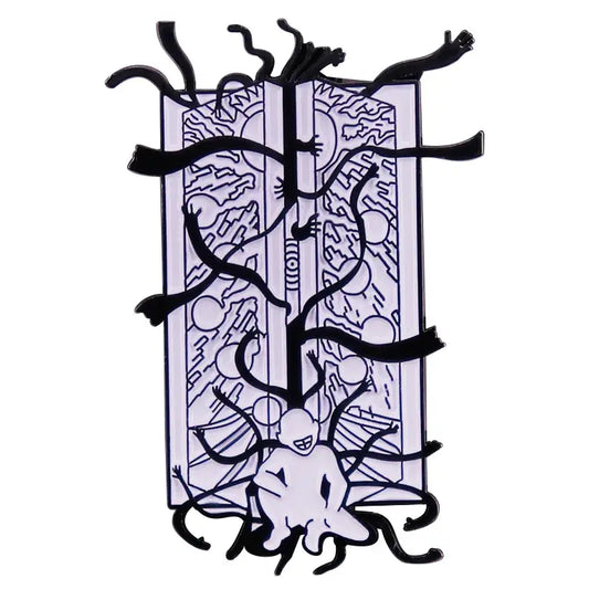 Black and white enamel pin featuring a surreal fullmetal alchemist gate of truth design on an open book background