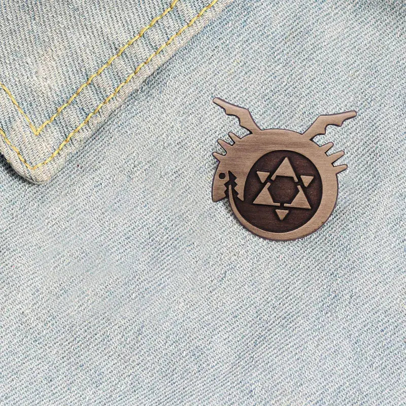 Wooden fullmetal alchemist enamel pin featuring a stylized dragon and geometric emblem metal badge design