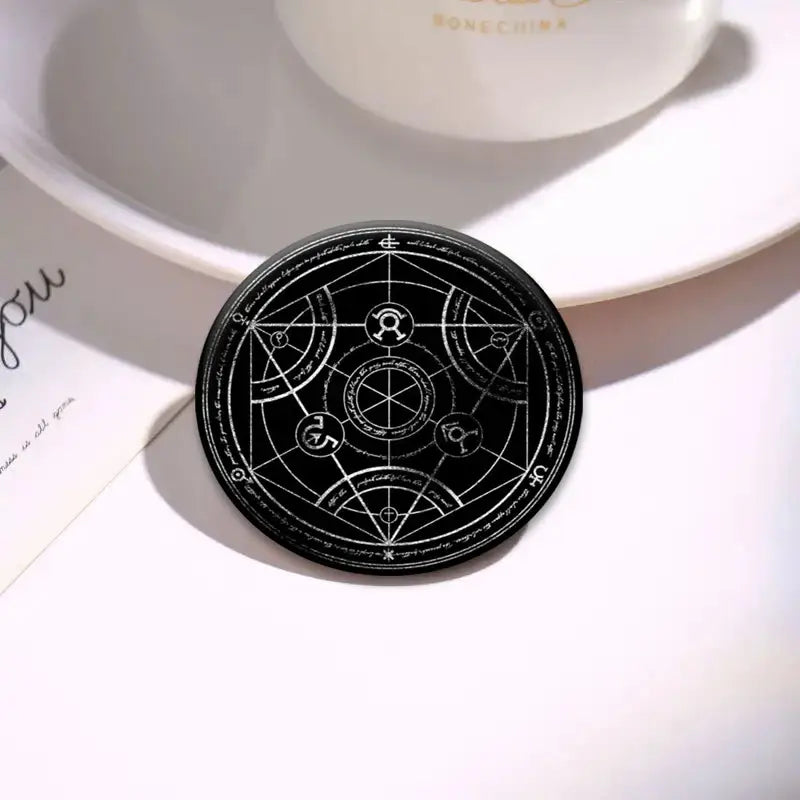 Black circular enamel pin featuring intricate white geometric and mystical symbols from fullmetal alchemist roy mustang