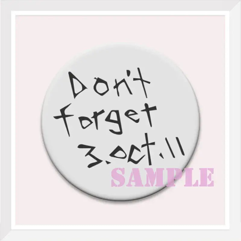 White circular enamel pin with black handwritten dont forget 3.oct.11 text from fullmetal alchemist roy mustang badge
