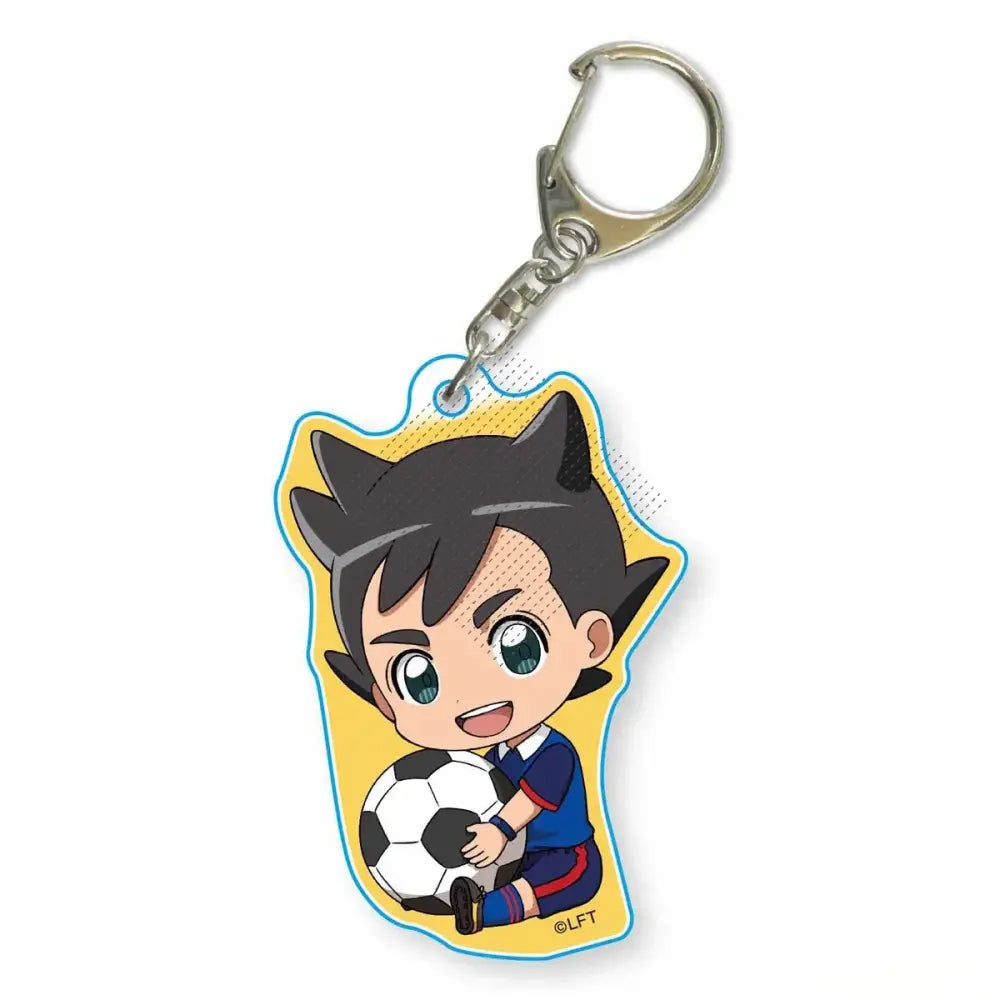 A yellow acrylic keychain featuring a chibi asuto inamori from game inazuma eleven holding a soccer ball