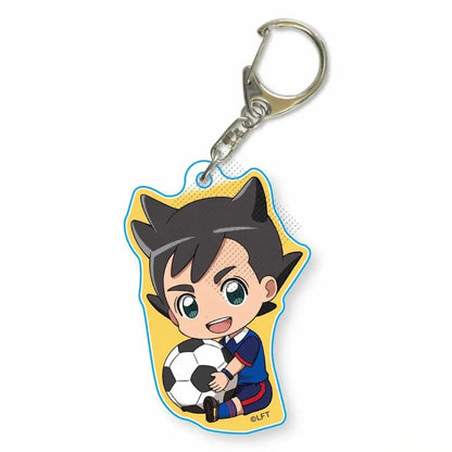 A yellow acrylic keychain featuring a chibi asuto inamori from game inazuma eleven holding a soccer ball