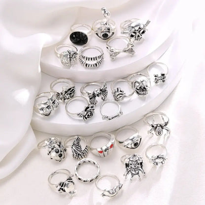 A silver-toned gothic skeleton ring set of 24pcs featuring intricate skulls bats spiders and punk designs