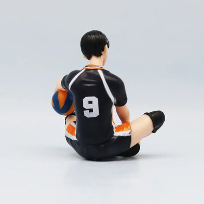 Back view of haikyuu shoyo hinata pvc figure sitting with blue and orange ball featuring white number 9 on black orange uniform