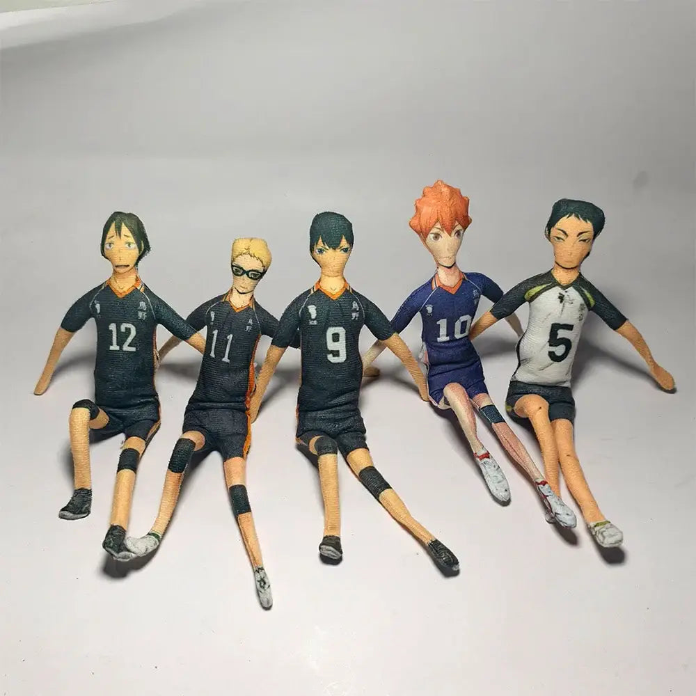 Five anime-style volleyball player figurines with detailed uniforms including tobio kageyama in black blue and white jerseys