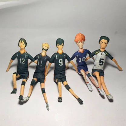 Five anime-style volleyball player figurines with detailed uniforms including tobio kageyama in black blue and white jerseys