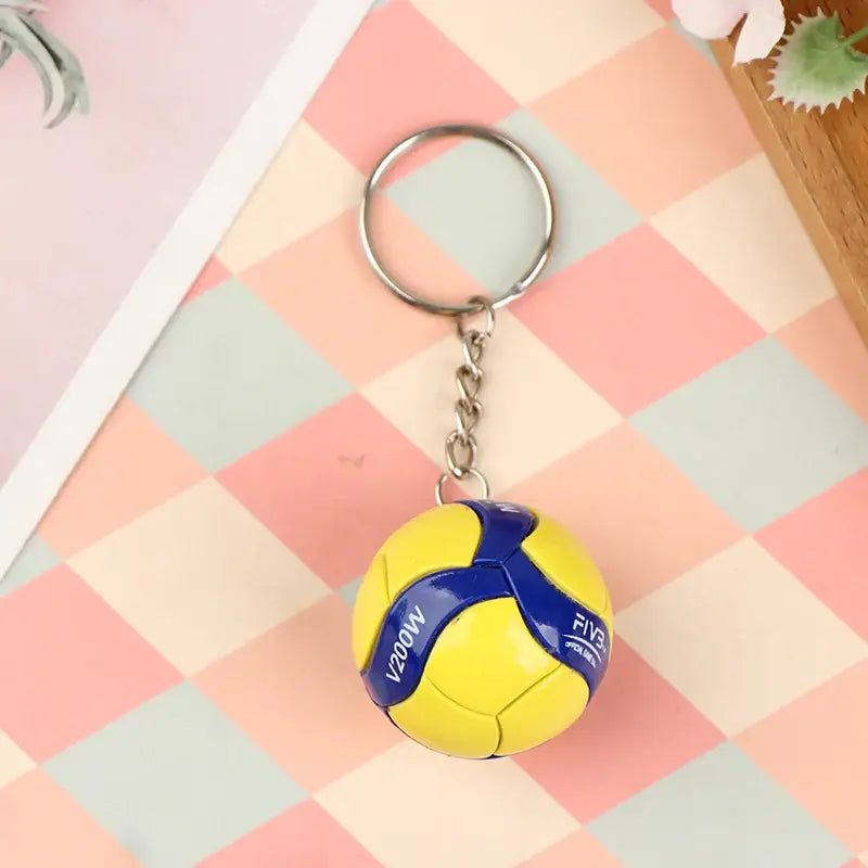Yellow and blue pvc volleyball keychain with v200w branding from haikyuu for sports fans and accessories