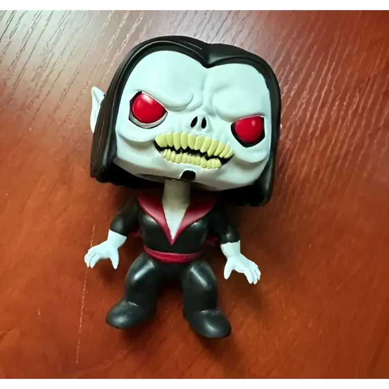 Black and white funko pop figure of a vampire with red eyes in a black suit with pink trim from high quality sword art online collection