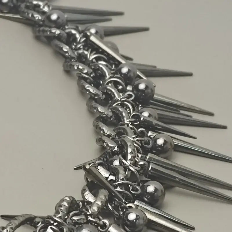 Silver spiked choker necklace with metallic balls and chain links paired with black gun metal biker pants chain