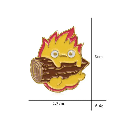 A yellow flame-like calcifer enamel pin with pink tips and white eyes on a brown log-shaped enamel pin base