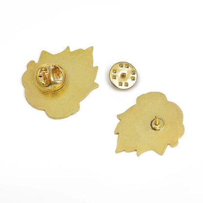 Gold-colored maple leaf-shaped enamel pin with textured surface and metallic backing for howl’s moving castle calcifer enamel pin
