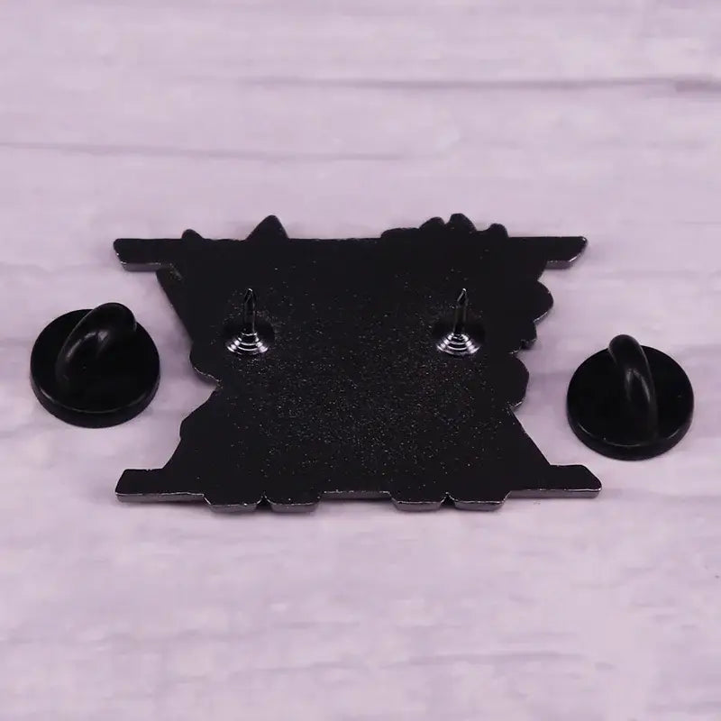 Black enamel pin shaped like a stylized train engine with silver fasteners and black backings from hunter x hunter cartoon badge
