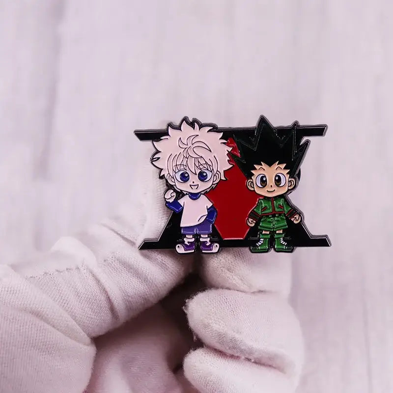A glossy enamel pin featuring hunter x hunter chibi characters killua and gon on a red cartoon badge background