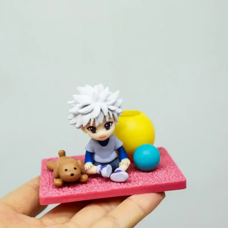Hunter x hunter killua zoldyck blind box anime figure with white spiky hair sitting on pink base with teddy bear and spheres
