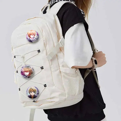 Cream-colored canvas backpack with three hunter x hunter kurapika round brooch pins attached to the front