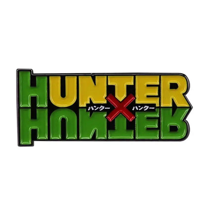 Green and yellow enamel hunter x hunter logo brooch with red x and japanese text fantasy adventure badge