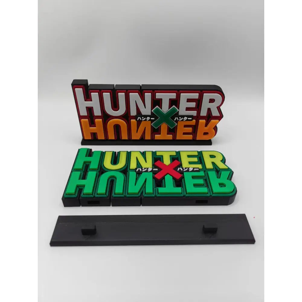 Two 3d-printed hunter x hunter logo stands in red white orange and green yellow with black bases for display