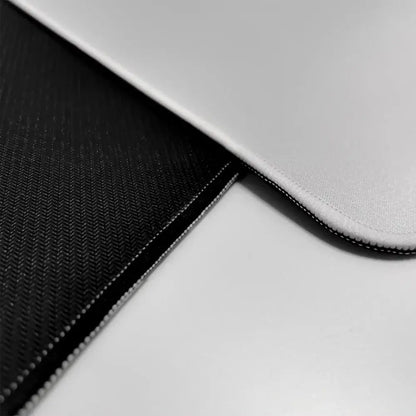 Black and silver laptop sleeve with textured fabric and stitched edges shown with hunter x hunter mouse pad rubber base
