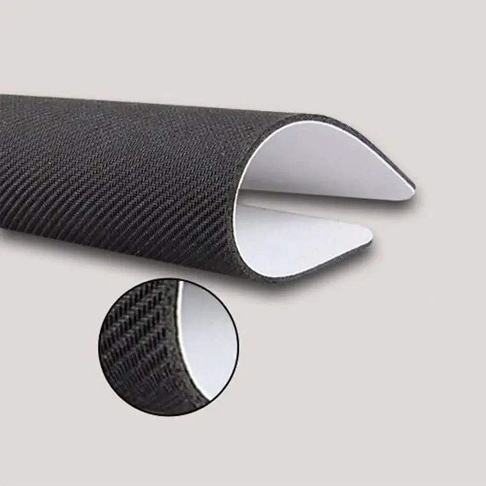 Black textured fabric edge protector with white adhesive interior on hunter x hunter mouse pad stitched edges back side