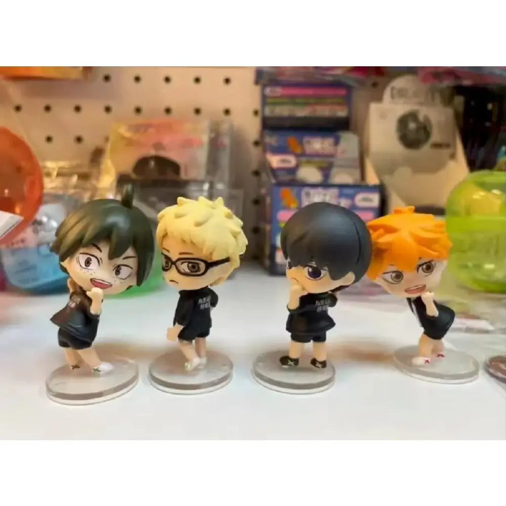 Four chibi-style volleyball boys figurines with green blonde black and orange hair in black team uniforms for unboxing video and support returns quality issues