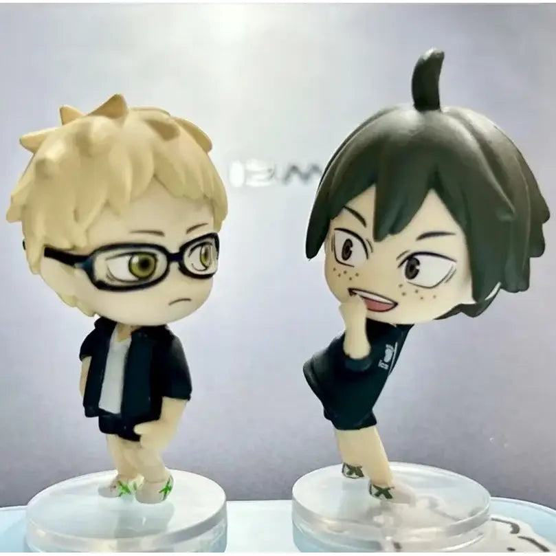 Two chibi-style volleyball boys figurines with blonde hair and glasses and dark green hair in team uniforms for unboxing video and support returns