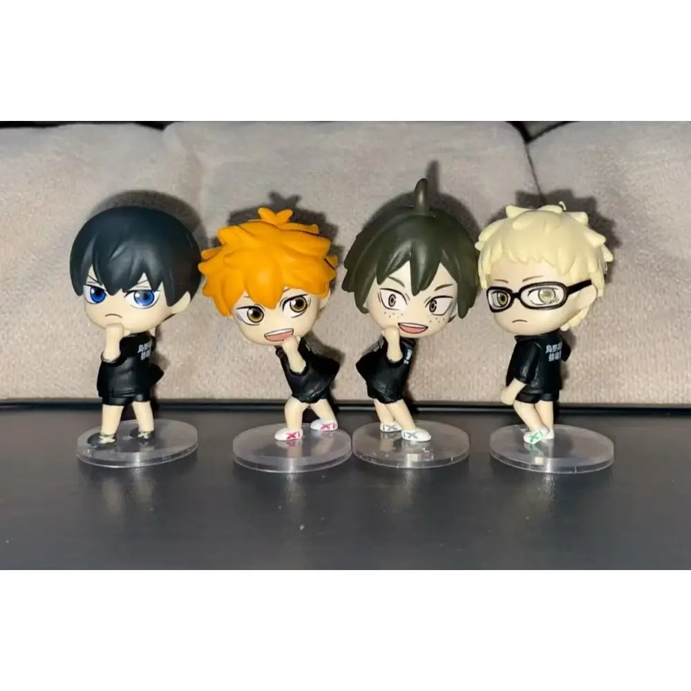 Four chibi-style volleyball boys figurines in black team uniforms on clear bases perfect for unboxing video and support returns