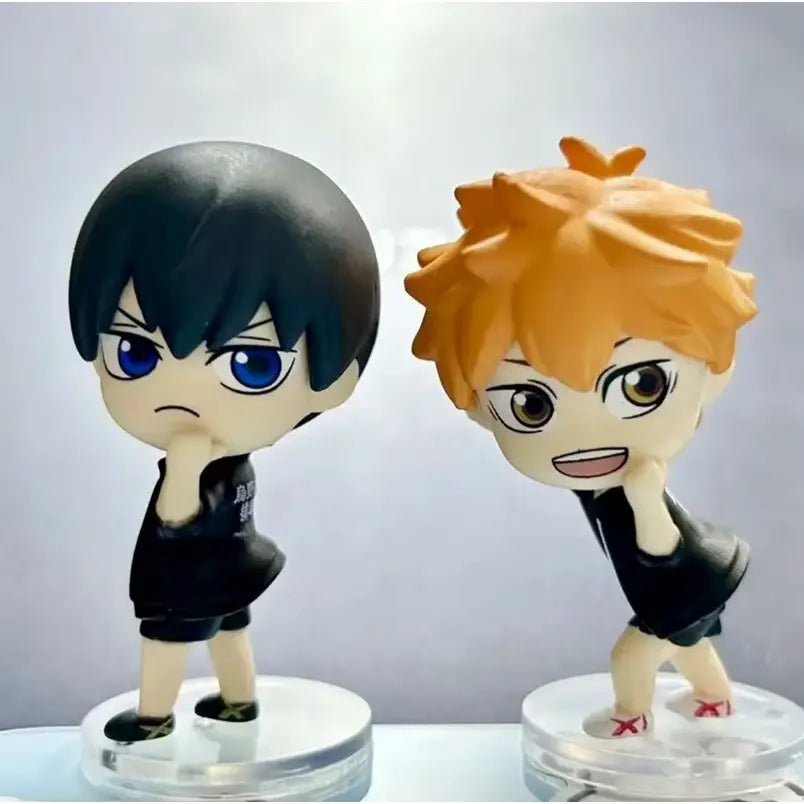 Two chibi-style volleyball boys figurines hinata with orange hair and kageyama with black hair in team uniform for unboxing video and support returns