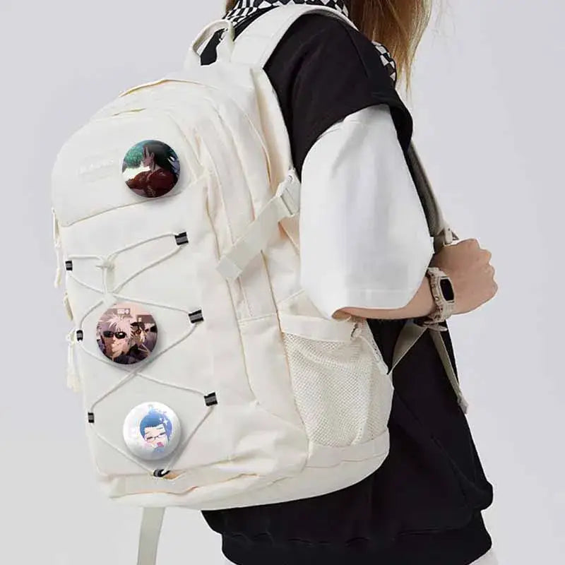 Cream-colored canvas backpack with three jujutsu kaisen geto suguru enamel pins attached as backpack accessory